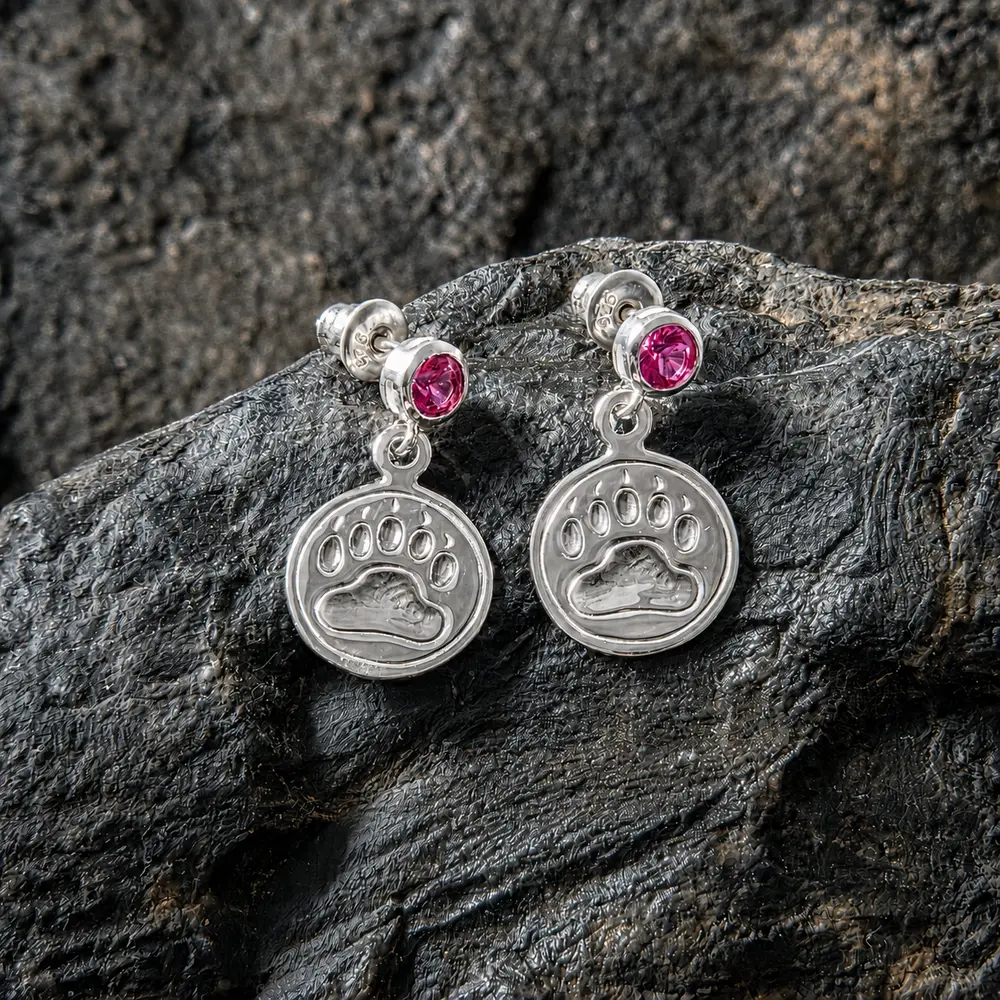 Sterling silver bear print earrings with faceted gemstone studs on textured fabric