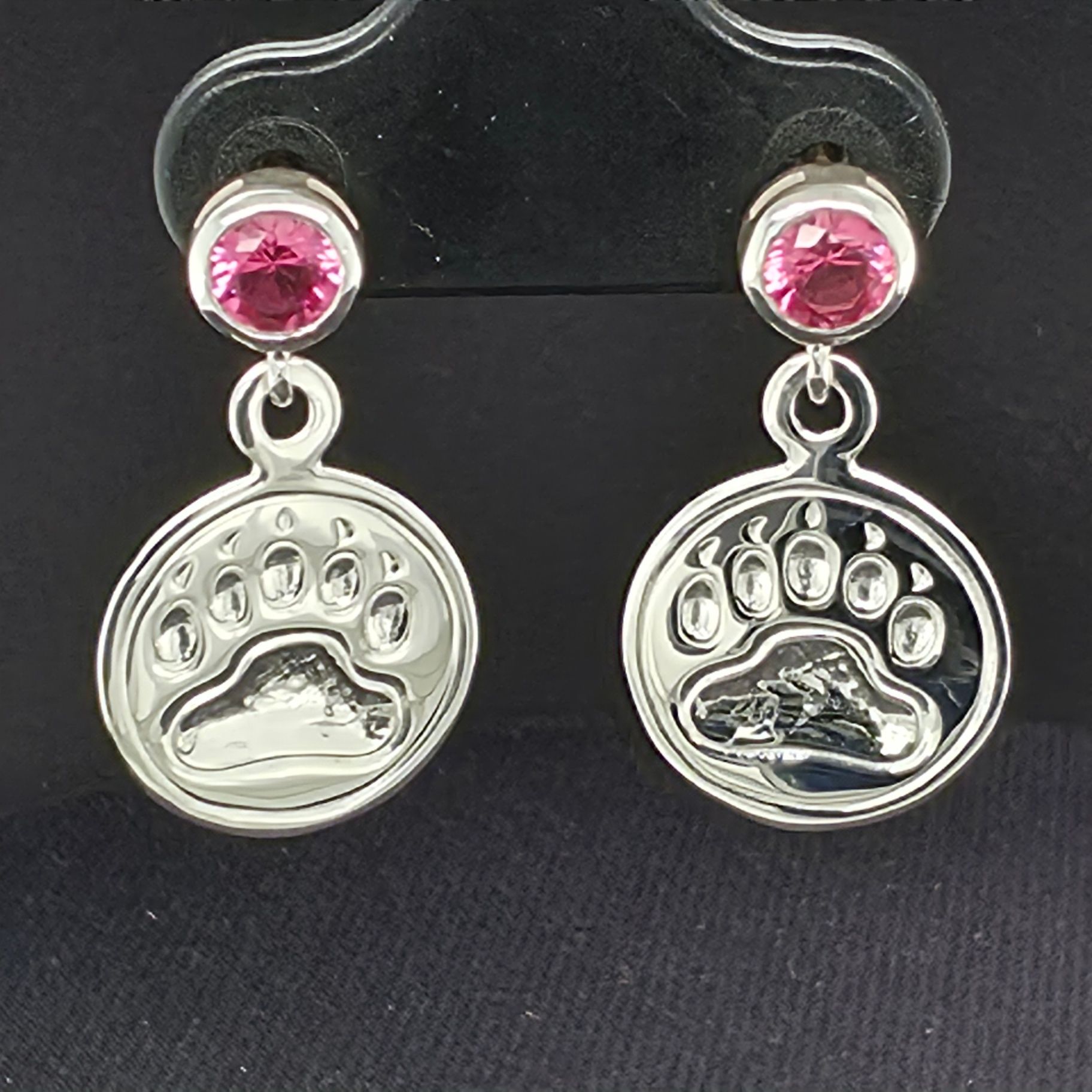 Front detail of the sterling silver bear print earrings with pink faceted gemstone studs